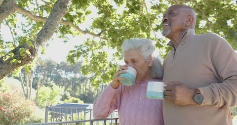 Senior Couple Enjoying Coffee Together in Sunny Garden