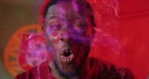 Energetic man with flag face paint released colors of celebration