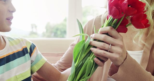 Child Giving Red Tulip Bouquet to Blond Woman Indoors - Download Free Stock Photos Pikwizard.com