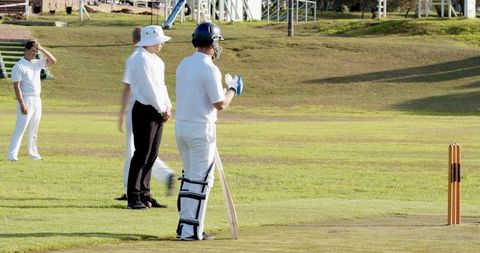 Cricketer Preparing to Bat on Cricket Field with Ultimate Focus