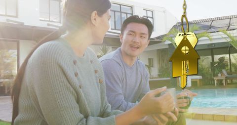 Couple relaxing by pool with dream home key overlay