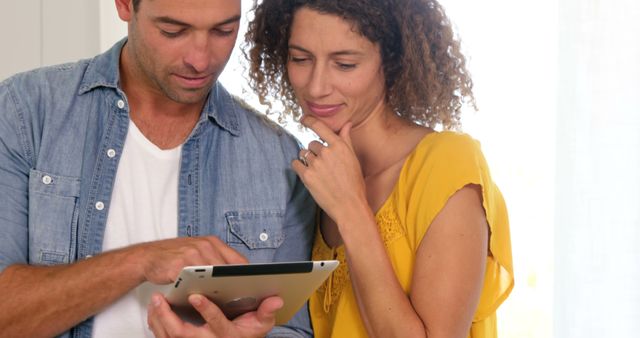 Focused couple using tablet with white background
