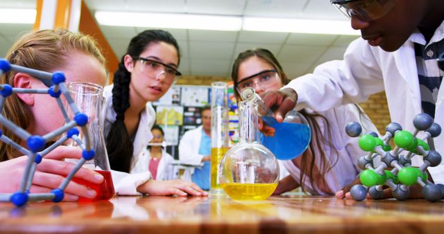 A diverse group of teenage students is engaged in a chemistry experiment in a laboratory, with copy space. They are closely observing a chemical reaction, indicative of a hands-on learning experience in science education.