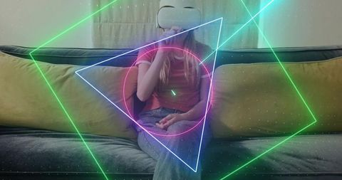 Woman experiencing virtual reality on sofa with neon holographic graphics