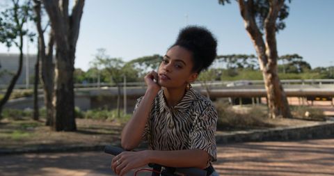 Biracial Woman Enjoying Sunny Day with Scooter in Park