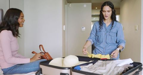 Diverse Friends Packing Suitcase for Vacation Adventure