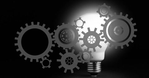 Glowing led bulb illuminating with mechanical gears overlay symbolizing innovation