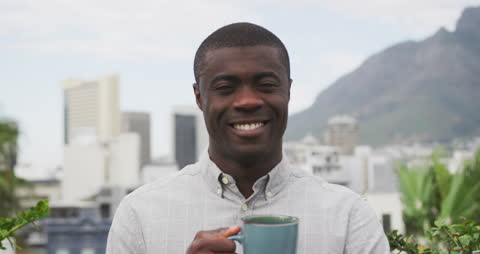 Smiling Man Enjoying Morning Coffee on Rooftop Terrace