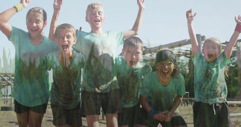 Excited Children Celebrating Muddy Outdoor Team Adventure