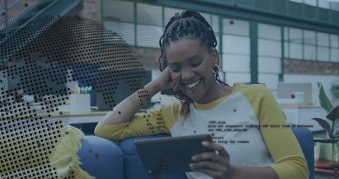 Smiling african american woman using tablet in tech office