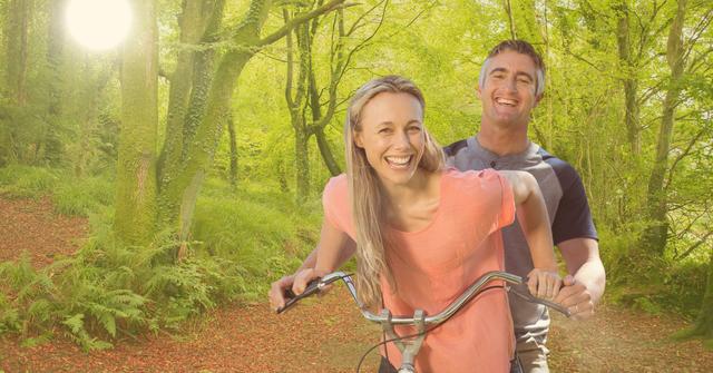 Digital composite of happy couple riding bicycle in forest
