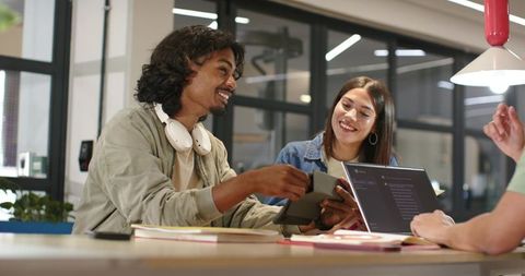 African american coworkers collaborating with tablet and laptop in modern coworking space
