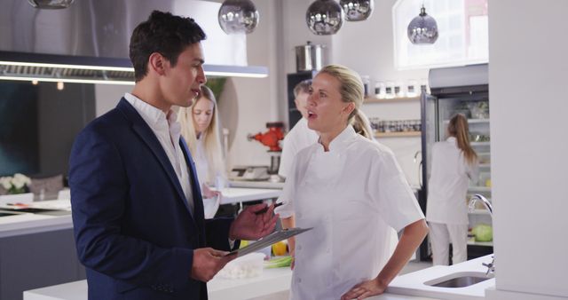 Chef Discussing Plans with Businessman in Modern Kitchen - Download Free Stock Images Pikwizard.com