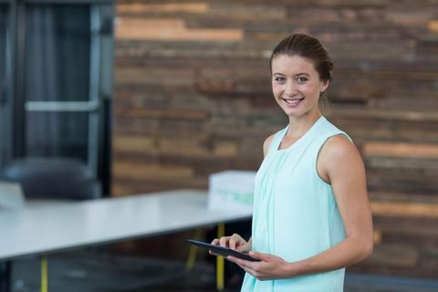 Confident Young Professional Using Tablet in Modern Office Space