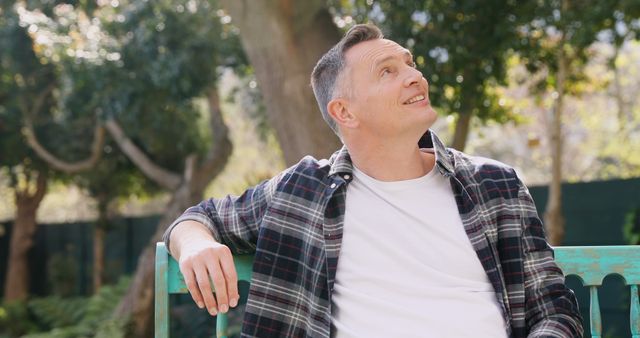 Man Relaxing on Park Bench Enjoying Nature with a Thoughtful Expression - Download Free Stock Images Pikwizard.com