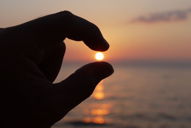 Hand Holding Sunrise Sun Over the Horizon at Tranquil Beach - Download Free Stock Images Pikwizard.com