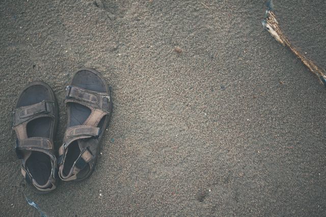 Pair of Worn Sandals on Sandy Beach - Download Free Stock Photos Pikwizard.com