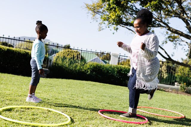 Grandmother and Granddaughter Playing with Hoops in Park - Download Free Stock Images Pikwizard.com