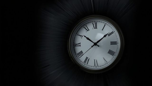 Analog clock with roman numerals on dark background