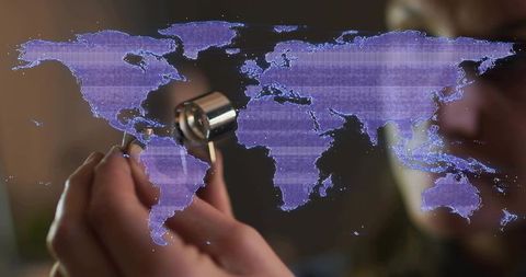Woman jeweler examining diamond ring under loupe with holographic world map overlay
