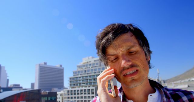 Man on Urban Rooftop Talking on Phone on a Sunny Day - Download Free Stock Images Pikwizard.com