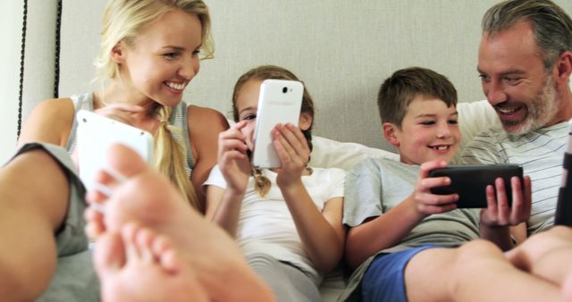 Happy Family Using Mobile Devices and Tablet Together Indoors - Download Free Stock Images Pikwizard.com