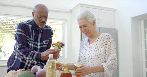 Happy Senior Couple Unpacking Grocery in Kitchen - Download Free Stock Images Pikwizard.com