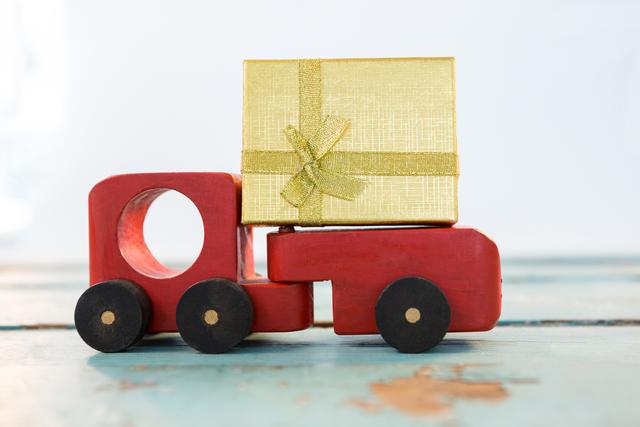 Toy Truck Carrying Christmas Present on Wooden Surface - Download Free Stock Photos Pikwizard.com