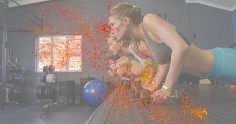 Three women performing incline pushups on bench with vibrant paint overlay, group fitness