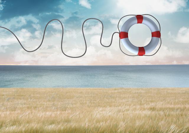 Lifebuoy with rope thrown in mid-air over an ocean and field landscape. Useful for themes related to safety, rescue operations, emergency preparedness, and life-saving techniques. Ideal for use in articles, advertisements, and educational materials about water safety and emergency response.