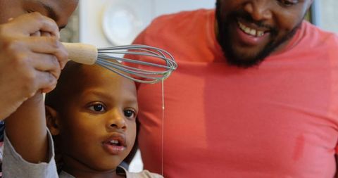 Parents Teaching Young Son Cooking in Modern Kitchen