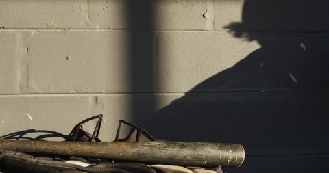 Female Baseball Equipment and Player Shadow on Brick Wall