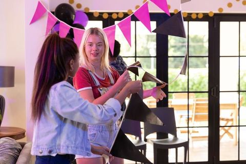 Female Friends Decorating Room for Festive Celebration