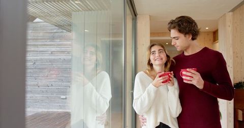 Couple Enjoying Morning Coffee Indoors by Deck View