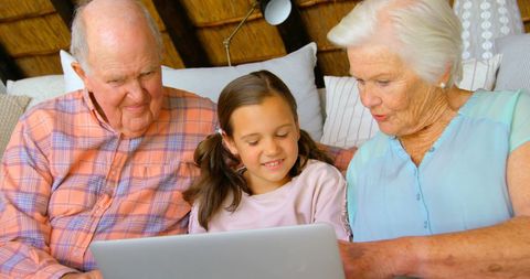 Grandparents Enjoying Technology with Young Granddaughter at Home