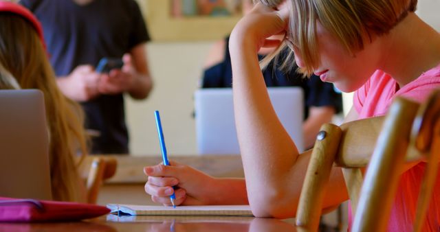 Focused Student Writing in Notebook in Classroom - Download Free Stock Images Pikwizard.com