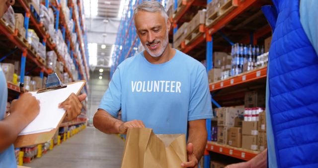 Smiling Elderly Volunteer Packing Food in Warehouse - Download Free Stock Images Pikwizard.com
