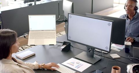 Modern Office Teamwork with Dual Monitors and Laptops