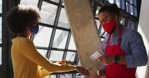 Cafe worker checking temperature during covid-19 safety protocols