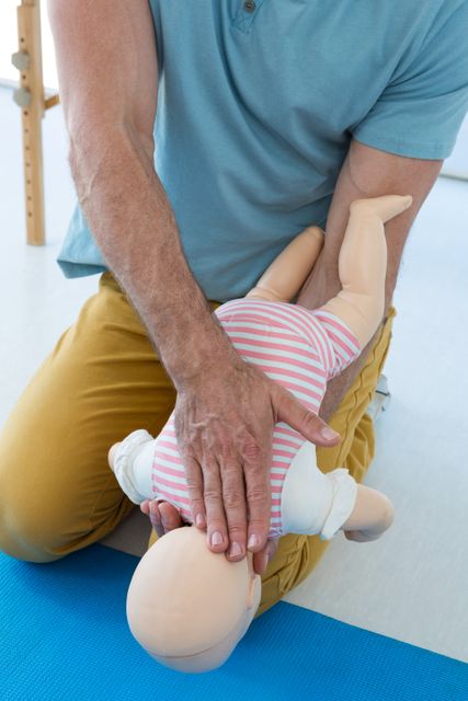 Paramedic demonstrating infant CPR on a dummy, showcasing lifesaving techniques. Ideal for use in medical training materials, first aid courses, healthcare education, and emergency response guides.