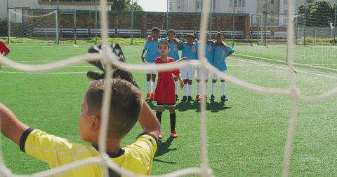Young boy taking penalty kick on soccer field