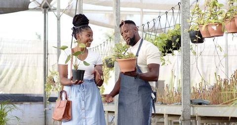 Man and Woman Enjoying Plant Shopping in Greenhouse