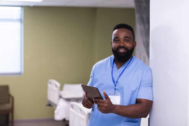 Portrait of smiling, bearded african american male doctor using tablet in hospital ward, copy space - Download Free Stock Photos Pikwizard.com