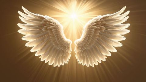 Divine white angel wings with radiant golden light