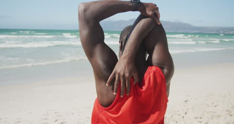 Fitness Enthusiast Stretching by the Sea