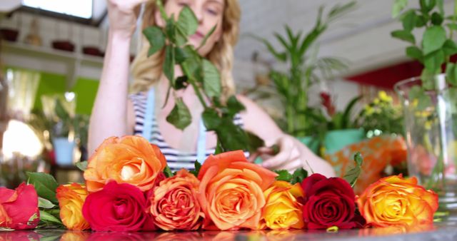 Female florist arranging roses in flower shop