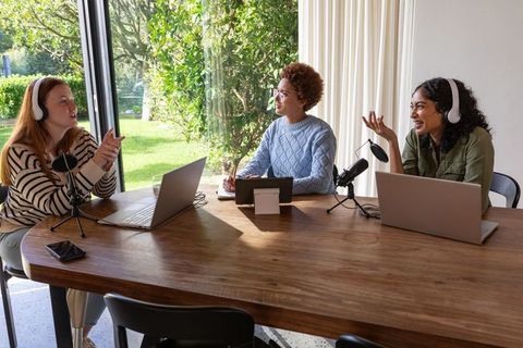 Diverse women recording podcast in modern home studio