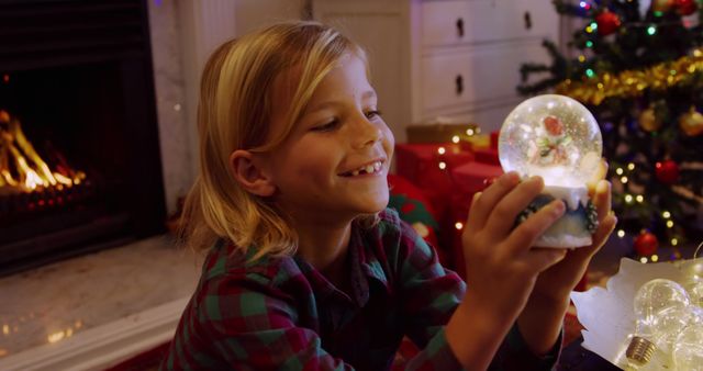 Happy Child Admiring Snow Globe Near Christmas Tree - Download Free Stock Images Pikwizard.com