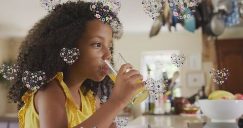 Curly Haired Girl Sipping Juice with Digital Hearts