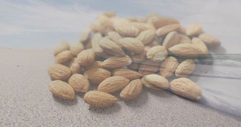Almonds blending with sandy beach double exposure for healthy snack and summer lifestyle